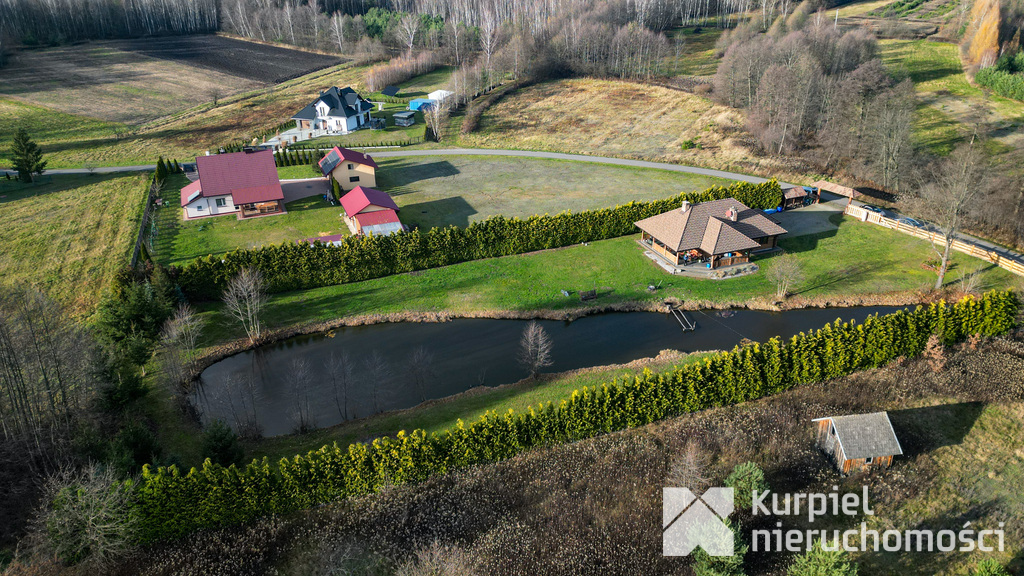 Dom z pełnego bala z zarybionym stawem