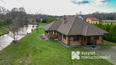 Dom z pełnego bala z zarybionym stawem