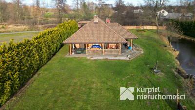 Dom z pełnego bala z zarybionym stawem