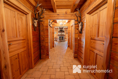 Dom z pełnego bala z zarybionym stawem