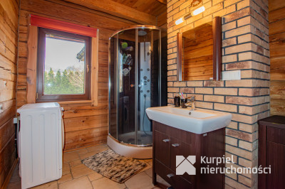 Dom z pełnego bala z zarybionym stawem