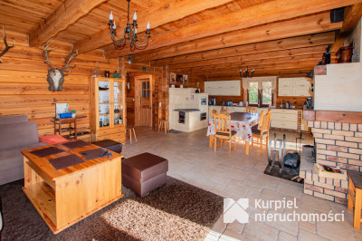 Dom z pełnego bala z zarybionym stawem