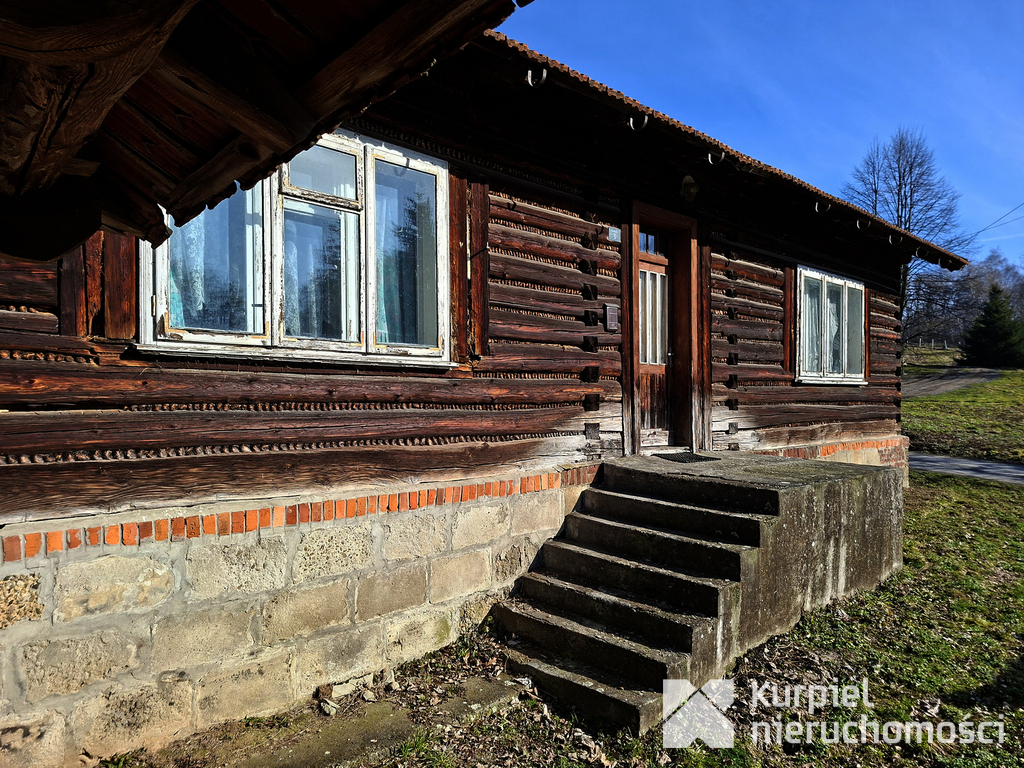 Drewniana chata z działką i zabudowaniami